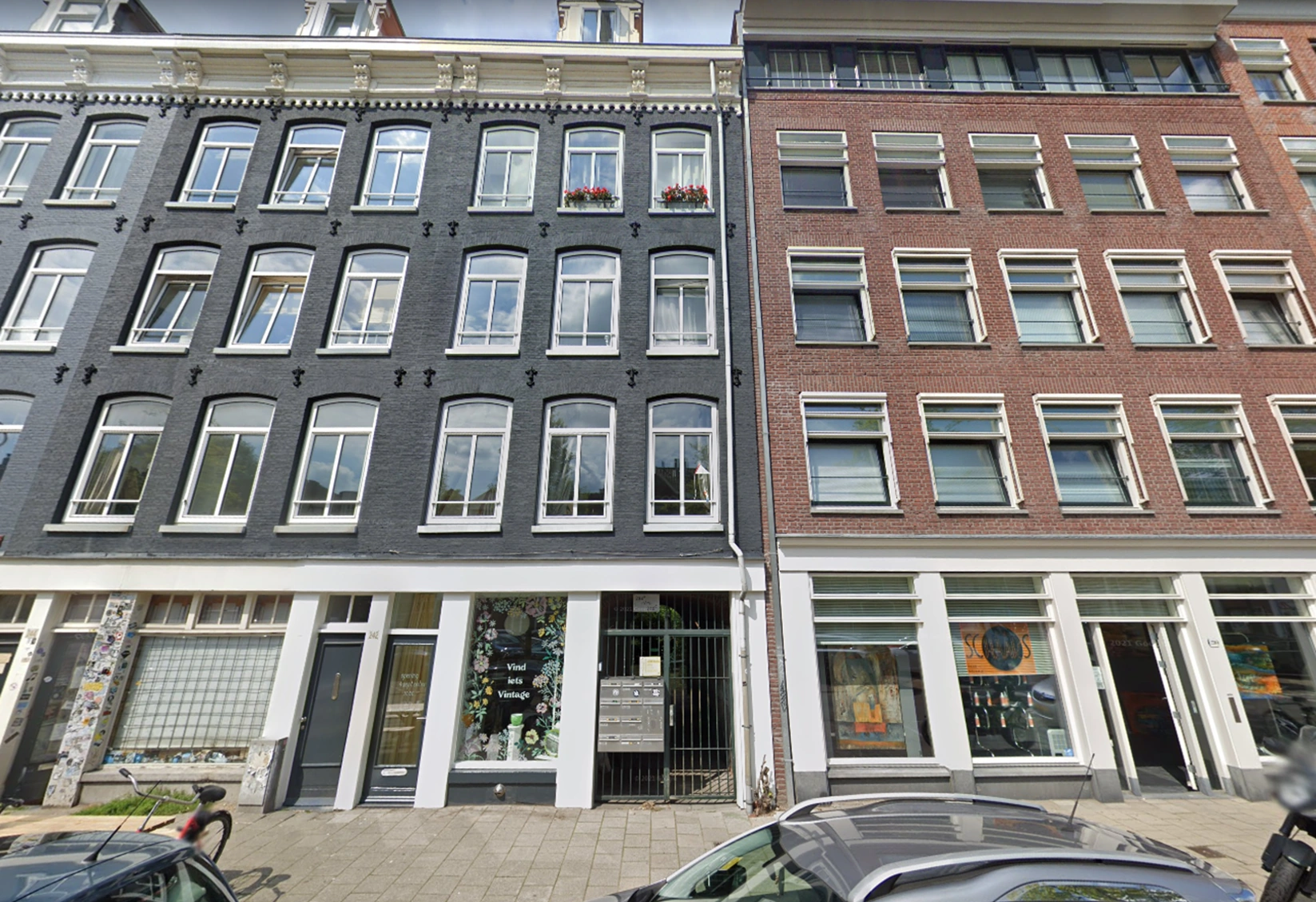 Voorgevel van een karakteristiek pand aan de Westerstraat in Amsterdam met winkels op de begane grond en appartementen erboven.