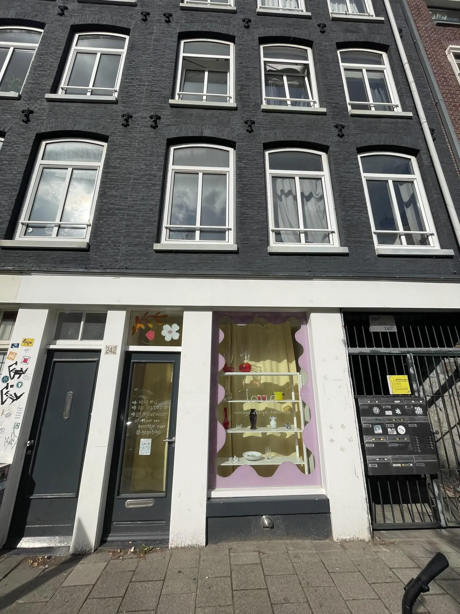 Winkelpui van Loua vintage design aan de Westerstraat met kleurrijke etalage en bovenliggende woonverdiepingen.