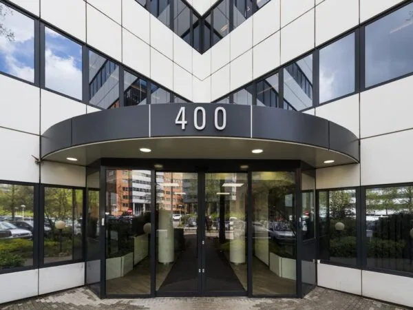 Glazen entree van kantoorgebouw met het nummer 400 boven de ingang.