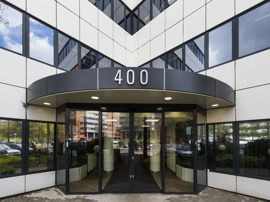 Glazen entree van kantoorgebouw met het nummer 400 boven de ingang.