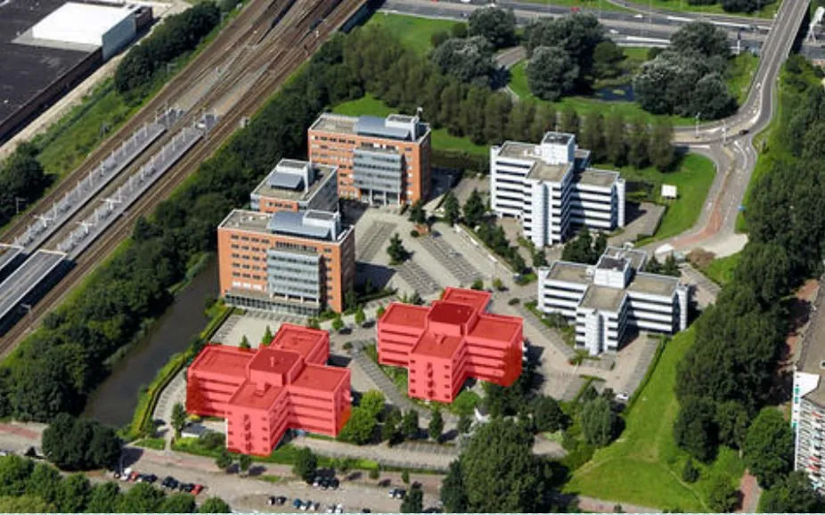 Luchtfoto van kantoorgebouwcomplex Entrada in Amsterdam, met drie rood gemarkeerde gebouwen op de voorgrond.