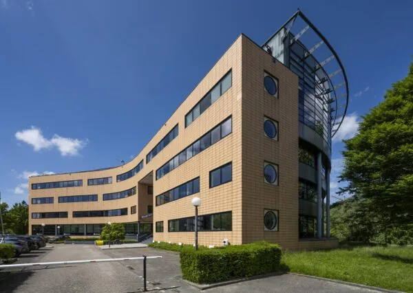 Kantoorgebouw aan de Wegalaan met moderne gevel en grote ramen op een zonnige dag.