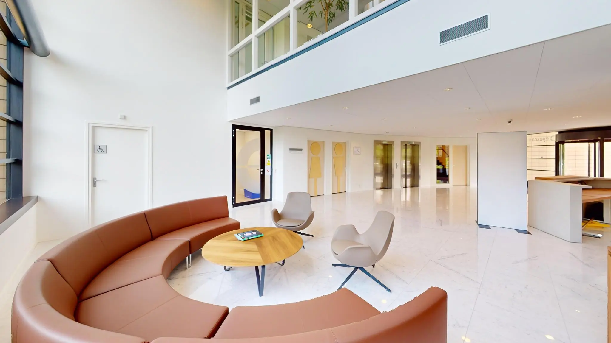 Moderne wachtruimte met ronde zithoek, designstoelen en koffie­tafels in een lichte, open kantooromgeving aan de Wegalaan.
