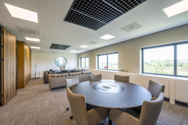 Modern kantoorinterieur aan de Wegalaan met vergadertafel, zithoek en uitzicht op groen landschap.