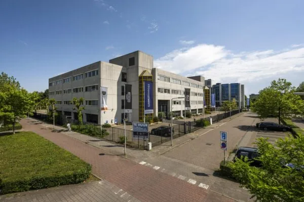 Kantoorgebouw Diemermere in Diemen met ‘Te Huur’-bord en omliggende parkeerplaatsen op een zonnige dag.