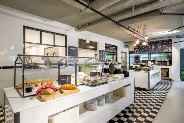Modern buffetrestaurant Diemermere met open keuken, vers brood, saladecups en een yoghurtbar op een zwart-wit geblokte tegelvloer.