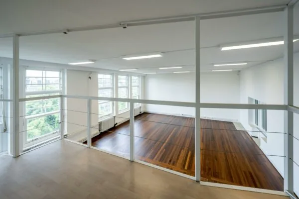 Lichte, moderne ruimte met grote ramen en een verdieping met houten vloer aan het WG-plein.