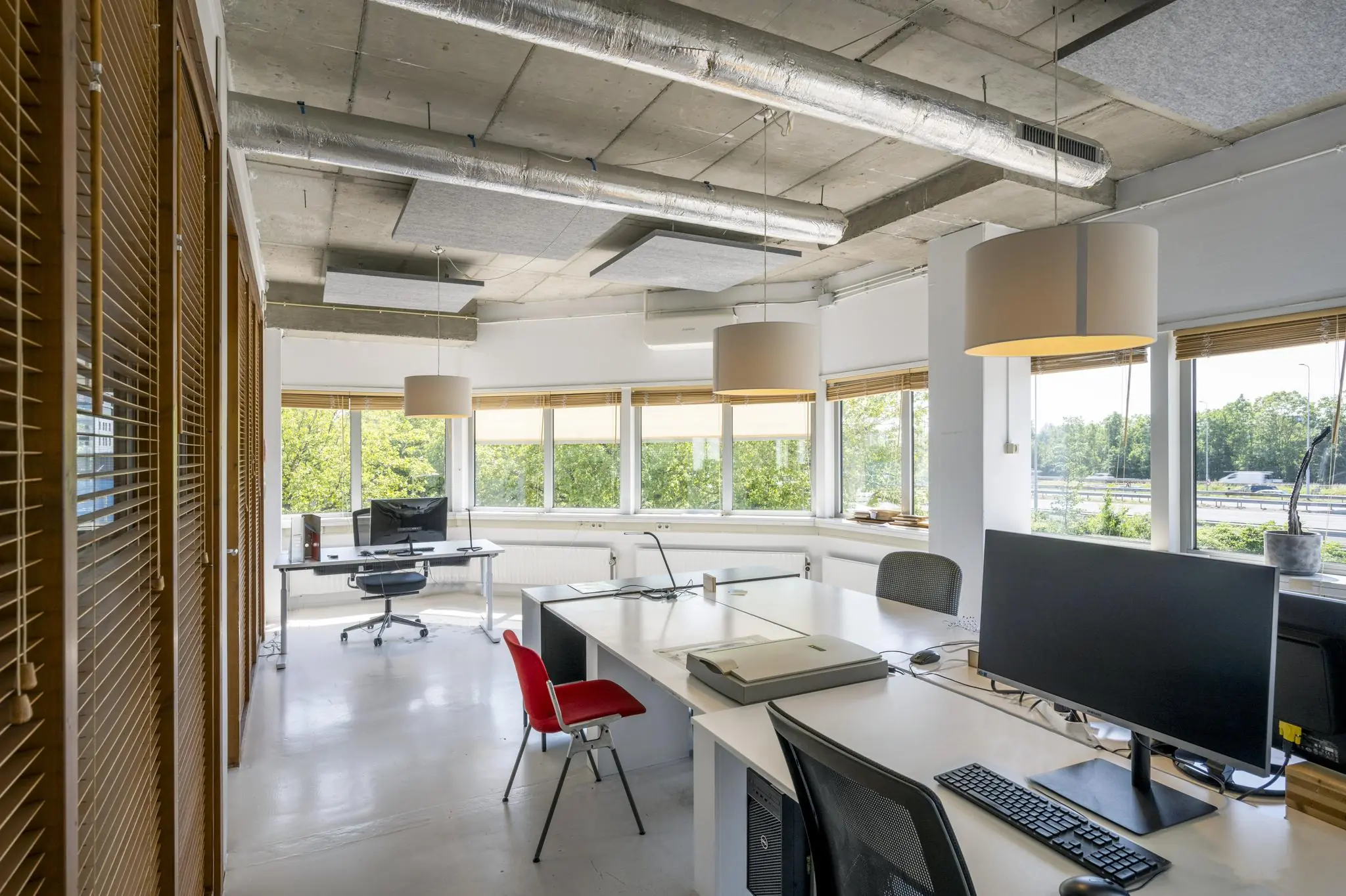 Modern kantoorinterieur aan de Anthony Fokkerweg met grote ramen, bureaus en industriële plafondafwerking.