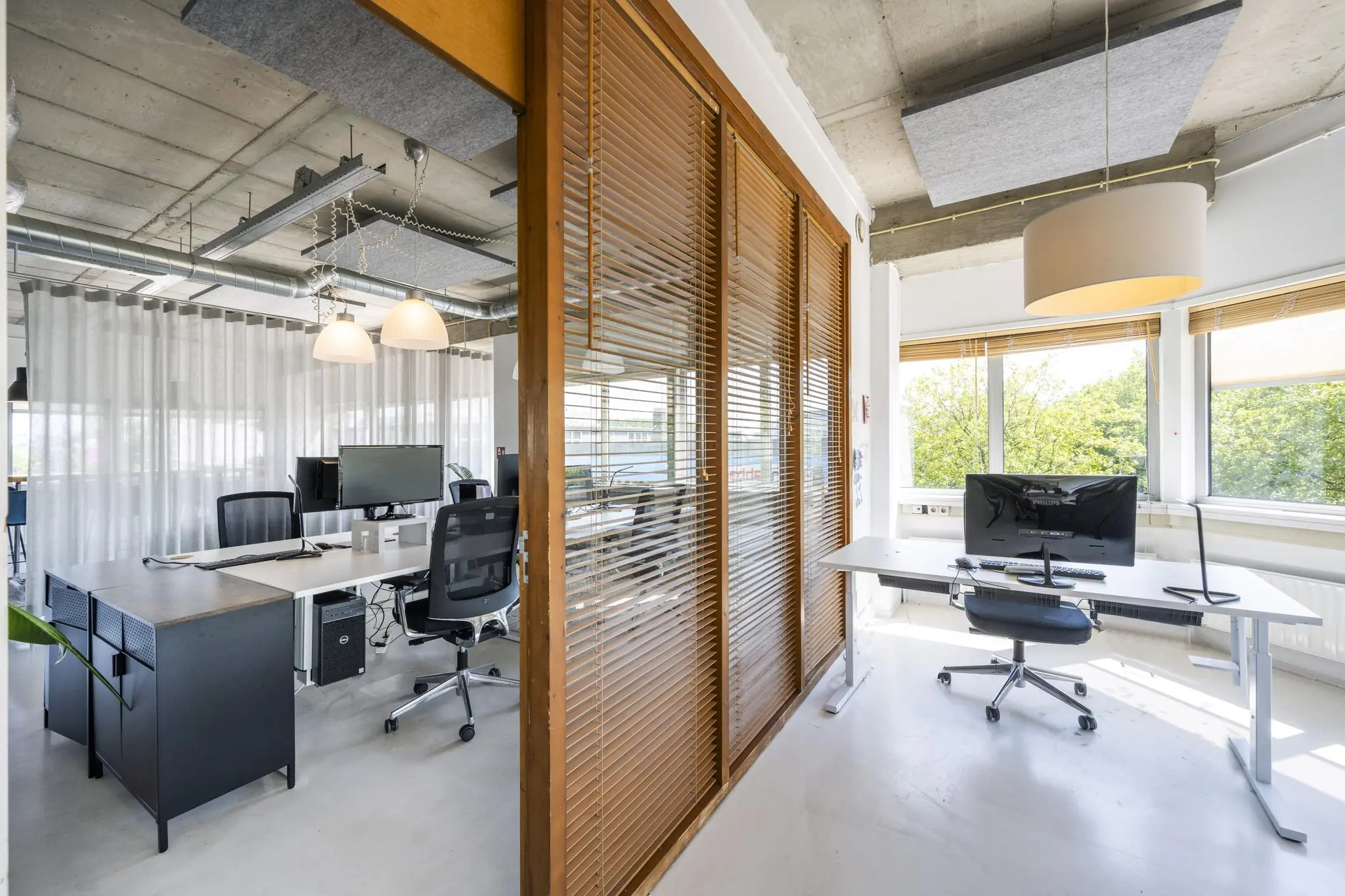 Modern kantoorinterieur aan de Anthony Fokkerweg met werkplekken, bureaus en grote ramen die uitzicht bieden op groen.