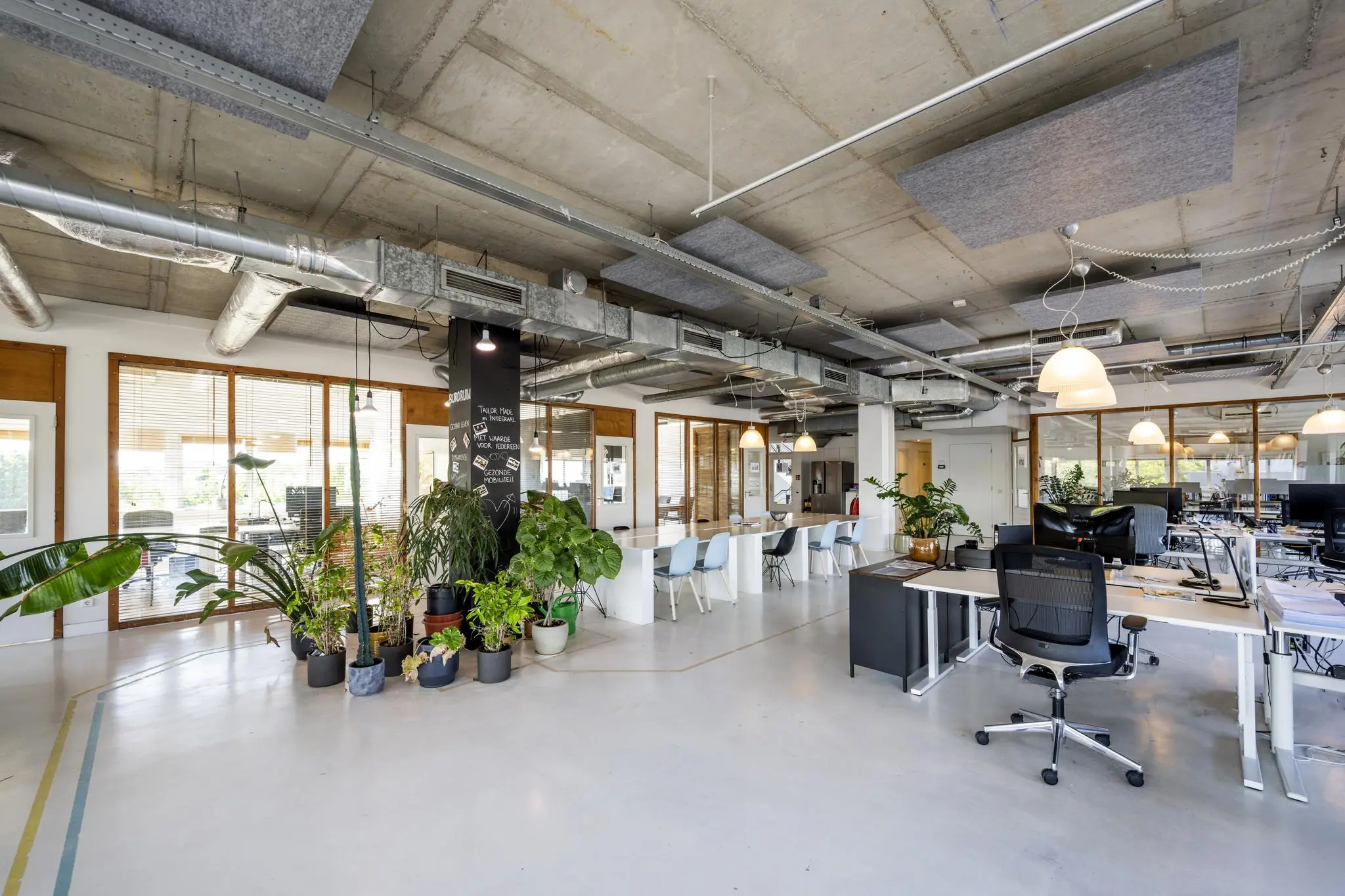 Modern en licht kantoorinterieur aan de Anthony Fokkerweg met open werkplekken, vergaderruimte en veel groen.
