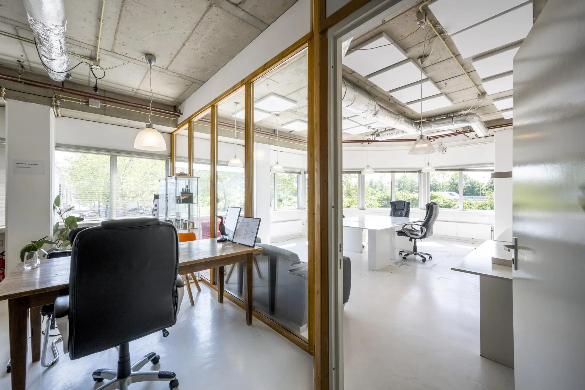 Modern en licht kantoorinterieur aan de Anthony Fokkerweg met grote ramen en industriële plafonddetails.