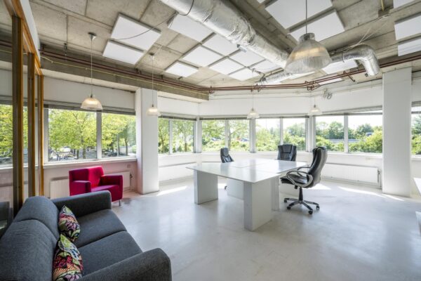 Licht en modern kantoorinterieur aan de Anthony Fokkerweg met grote ramen, bureaus en loungehoek.