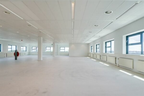 Ruime, lege kantoorruimte met witte muren, meerdere ramen en systeemplafond aan de Ringwade.