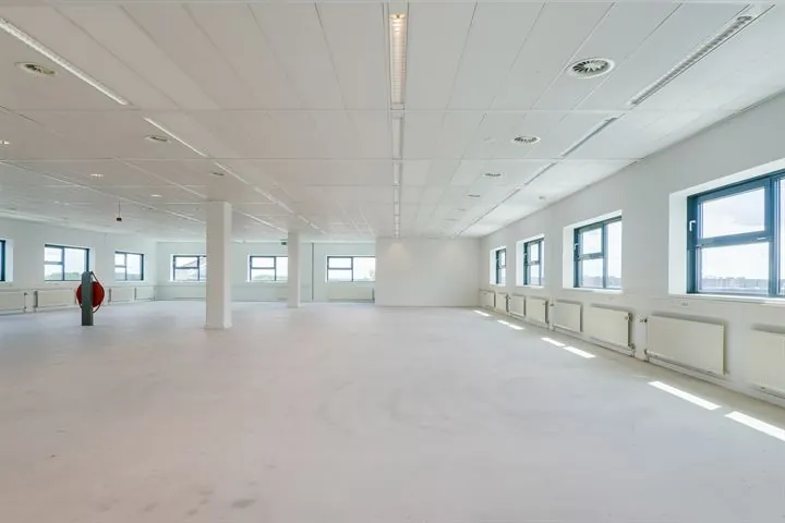 Ruime, lege kantoorruimte met witte muren, meerdere ramen en systeemplafond aan de Ringwade.