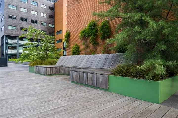 Houten zitelement met plantenbakken op een modern dakterras aan de Ringwade.