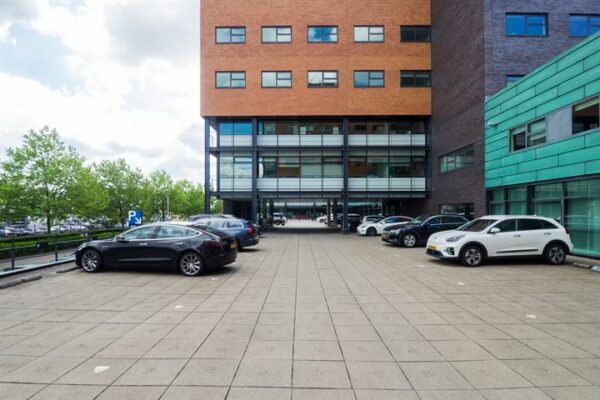 Parkeerterrein met geparkeerde auto's voor een modern kantoorgebouw aan de Ringwade.