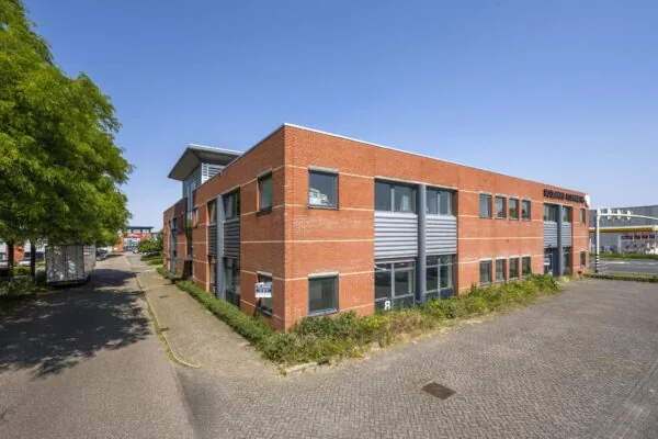 Bedrijfspand aan de Breguetlaan met rode bakstenen gevel en grijze accenten, gelegen op een bedrijventerrein.