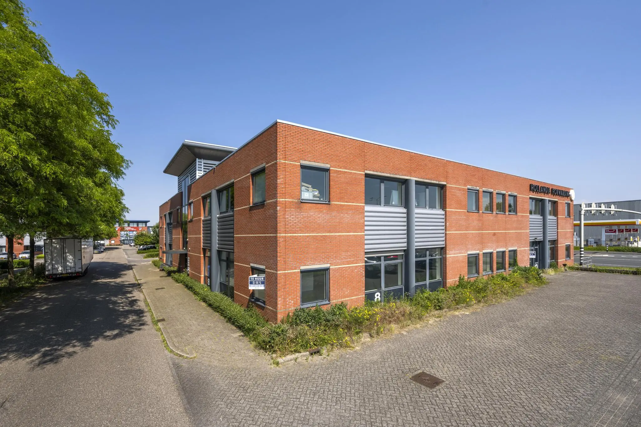 Bedrijfspand aan de Breguetlaan met rode bakstenen gevel en grijze accenten, gelegen op een bedrijventerrein.