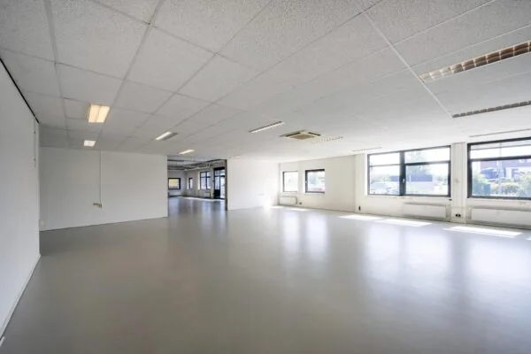 Lichte, lege kantoorruimte aan de Breguetlaan met grote ramen en systeemplafond.