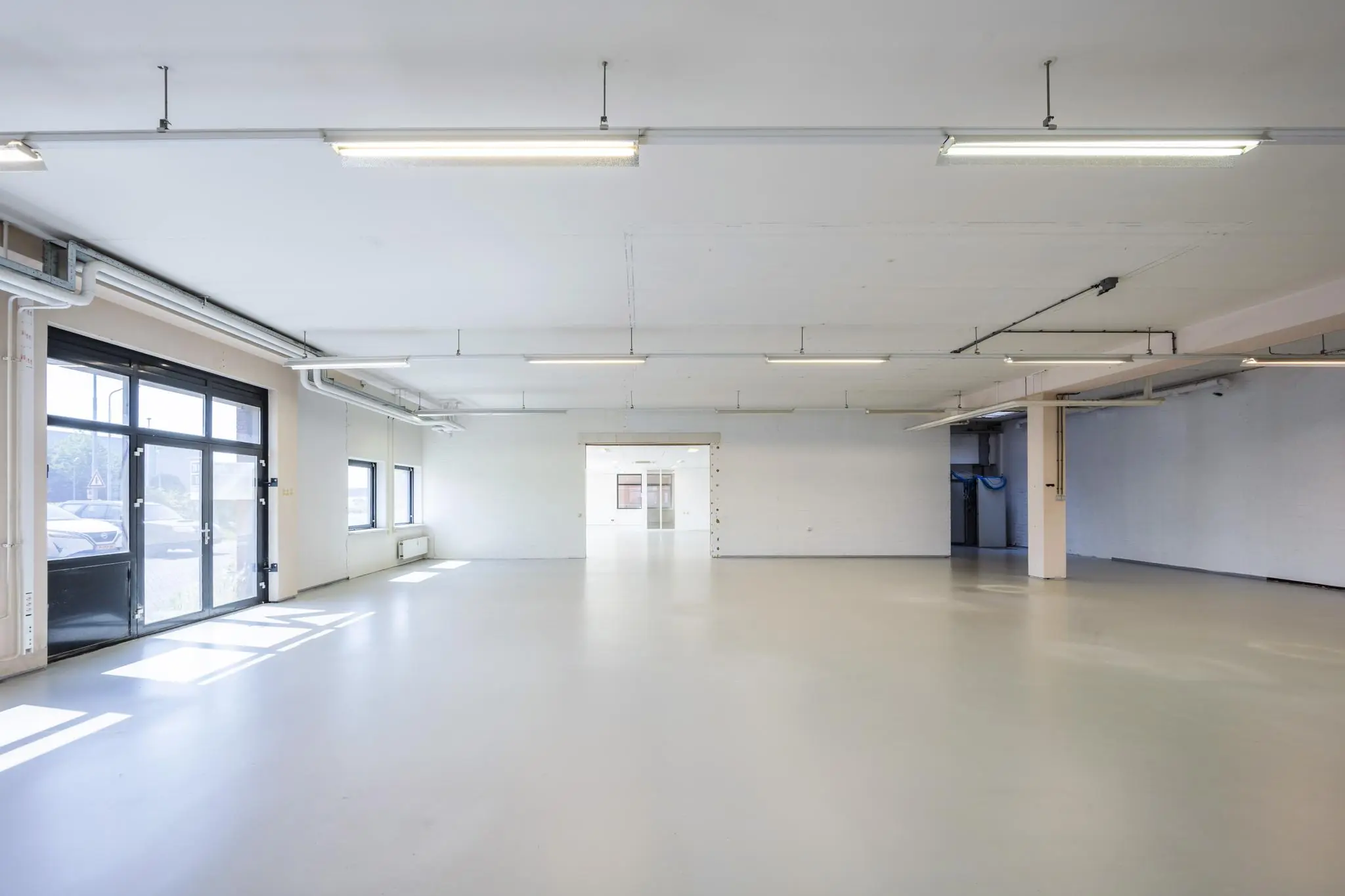 Ruime, lege bedrijfsruimte met witte muren en grote ramen aan de Breguetlaan.