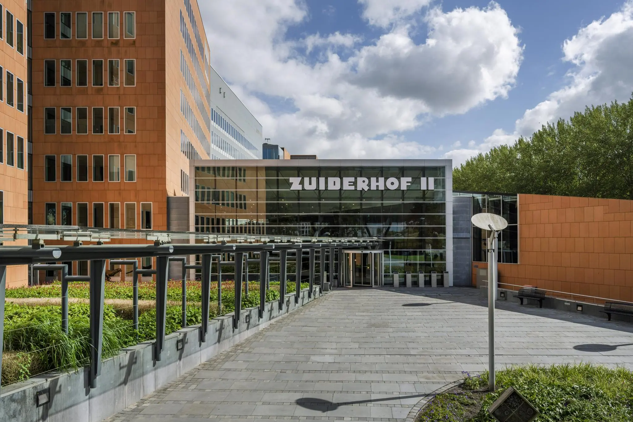 Ingang van het kantoorgebouw Zuiderhof II aan de Jachthavenweg, met moderne architectuur en een betegeld pad.