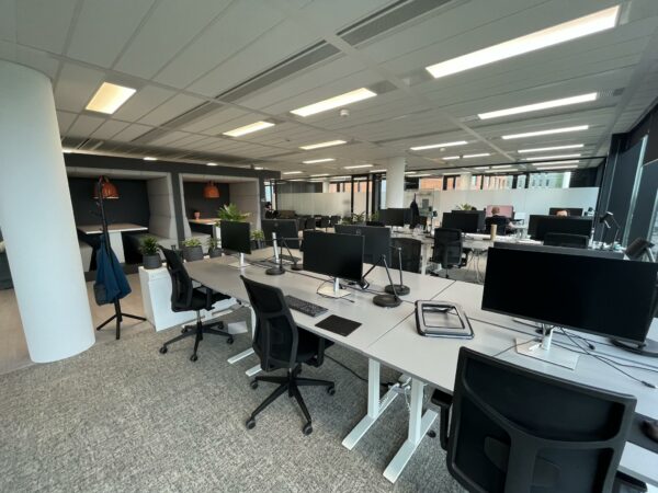 Moderne, open kantoortuin aan de Winthontlaan met werkplekken, computers en akoestische zithoeken.