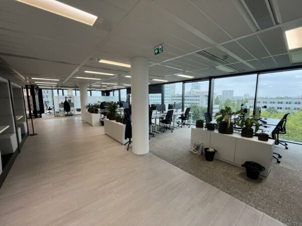 Moderne, open kantoorruimte aan de Winthontlaan met werkplekken, grote ramen en veel daglicht.