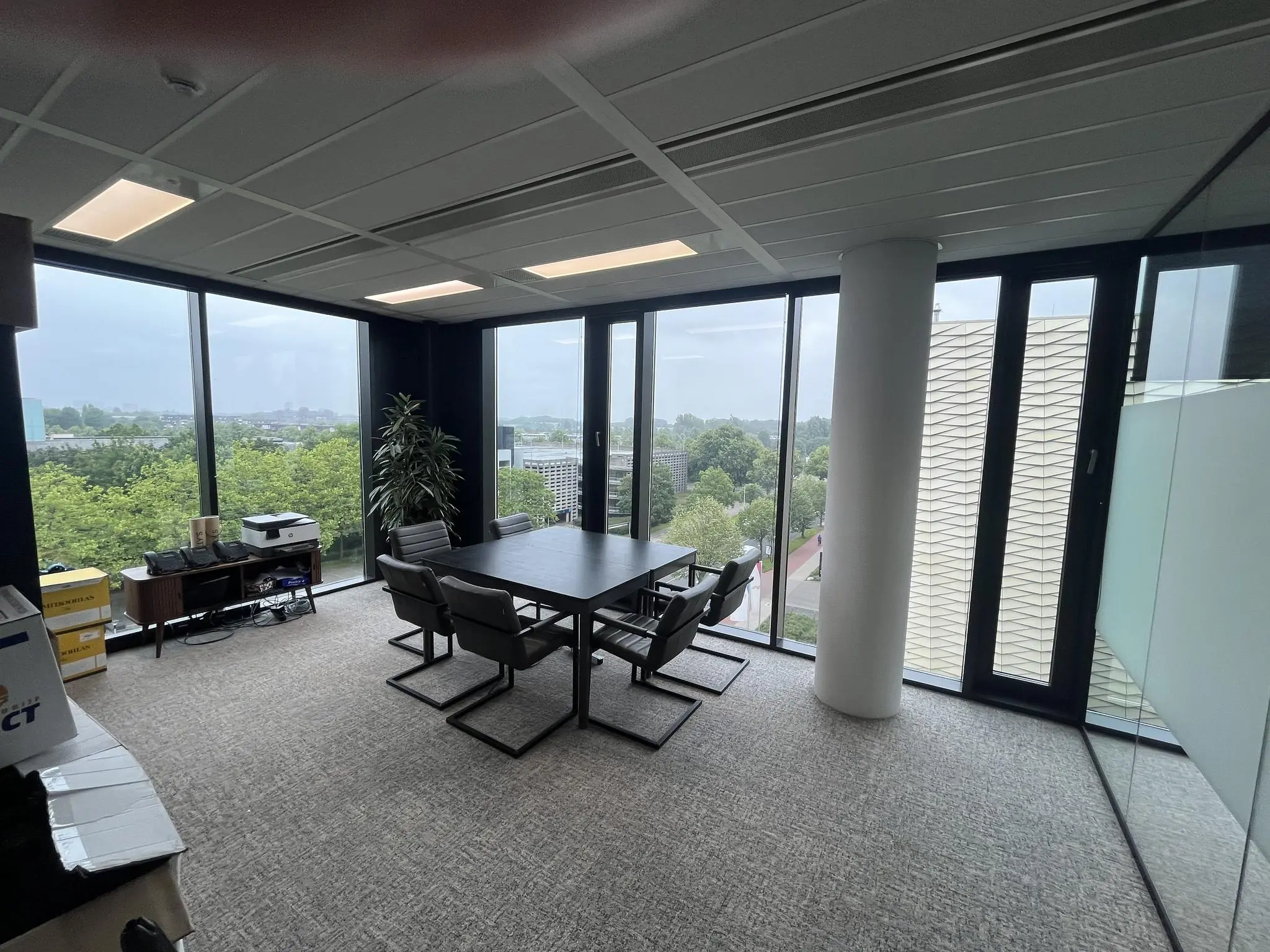 Vergaderruimte aan de Winthontlaan met grote ramen en uitzicht op groen stadslandschap.