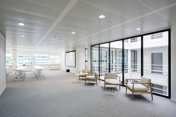 Moderne kantoorruimte aan de Burgemeester Stramanweg met vergadertafels, loungezitjes en grote raampartijen.