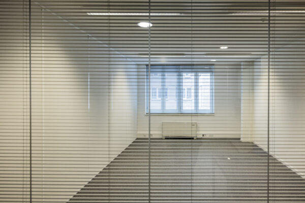Lege kantoorruimte met jaloezieën voor een glazen wand op de 19e etage in Vleuterweide.