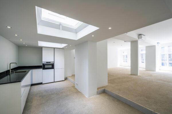 Lichte, ruime verdieping aan het Damrak met een moderne open keuken en grote raampartijen.