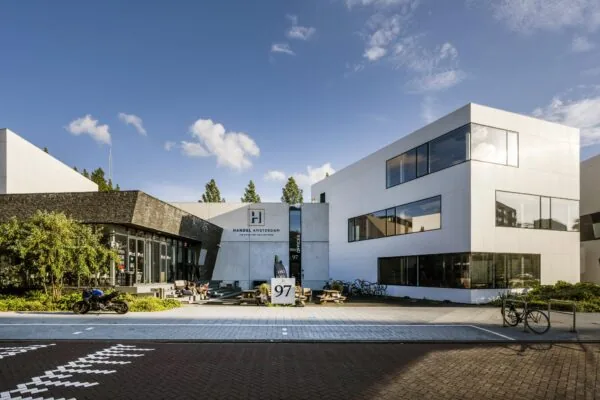Moderne witte kantoorpanden aan de Fred. Roeskestraat in Amsterdam met het Handelsgebouw en buitenterras op de voorgrond.