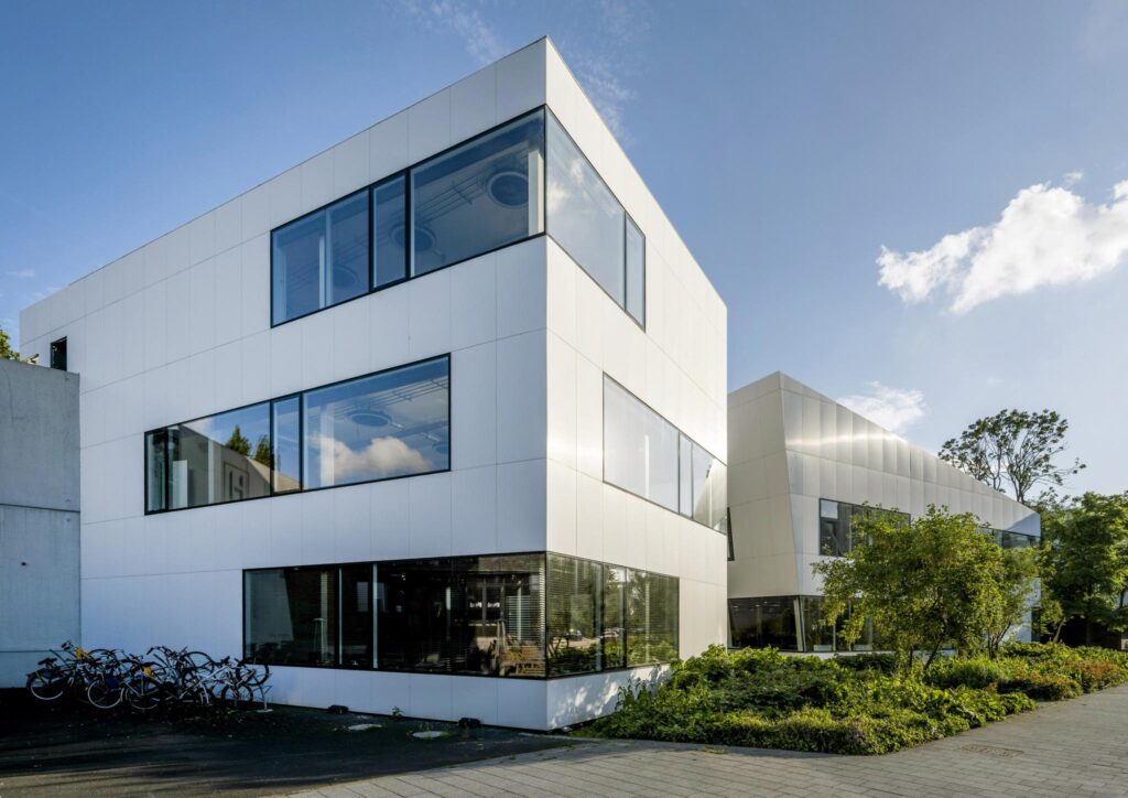 Modern wit kantoorgebouw aan de Fred. Roeskestraat met grote ramen en omliggend groen.