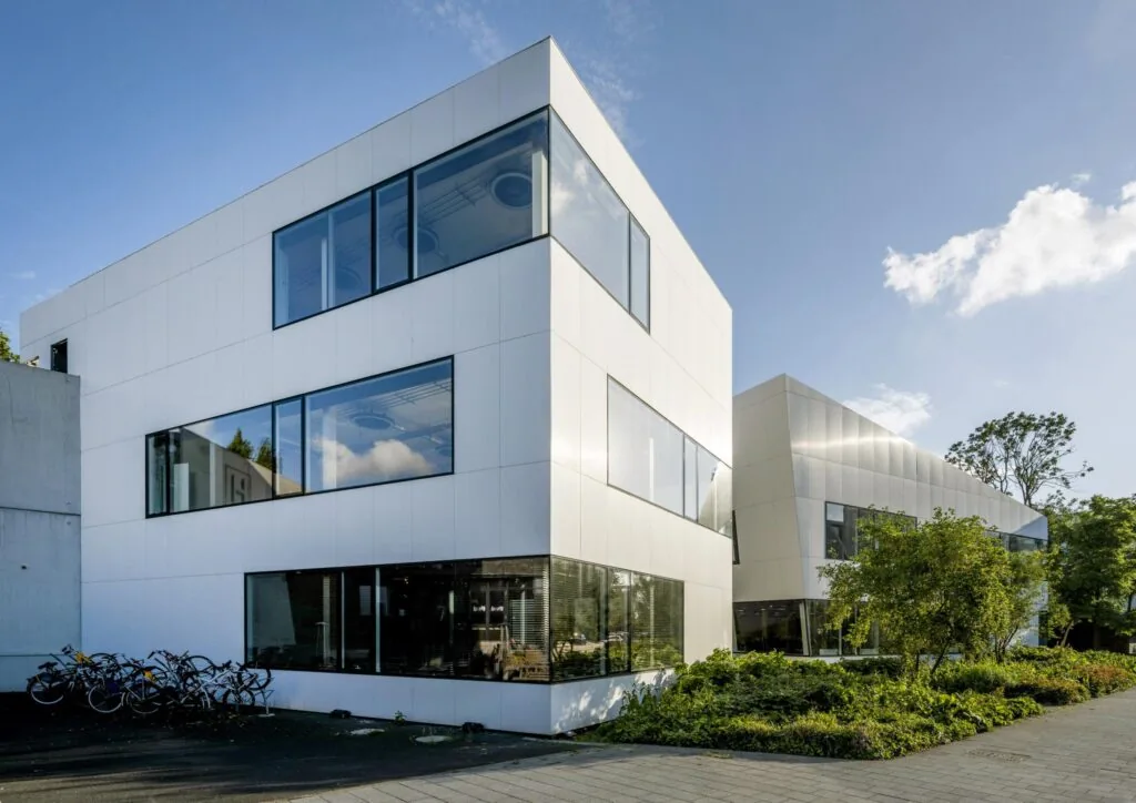 Modern wit kantoorgebouw aan de Fred. Roeskestraat met grote ramen en omliggend groen.