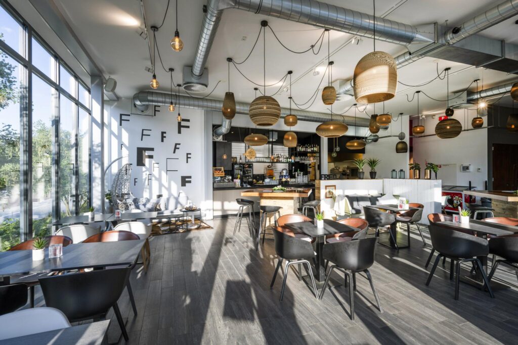 Modern ingericht café-restaurant op de Fred. Roeskestraat met veel natuurlijk licht, houten details en hanglampen.