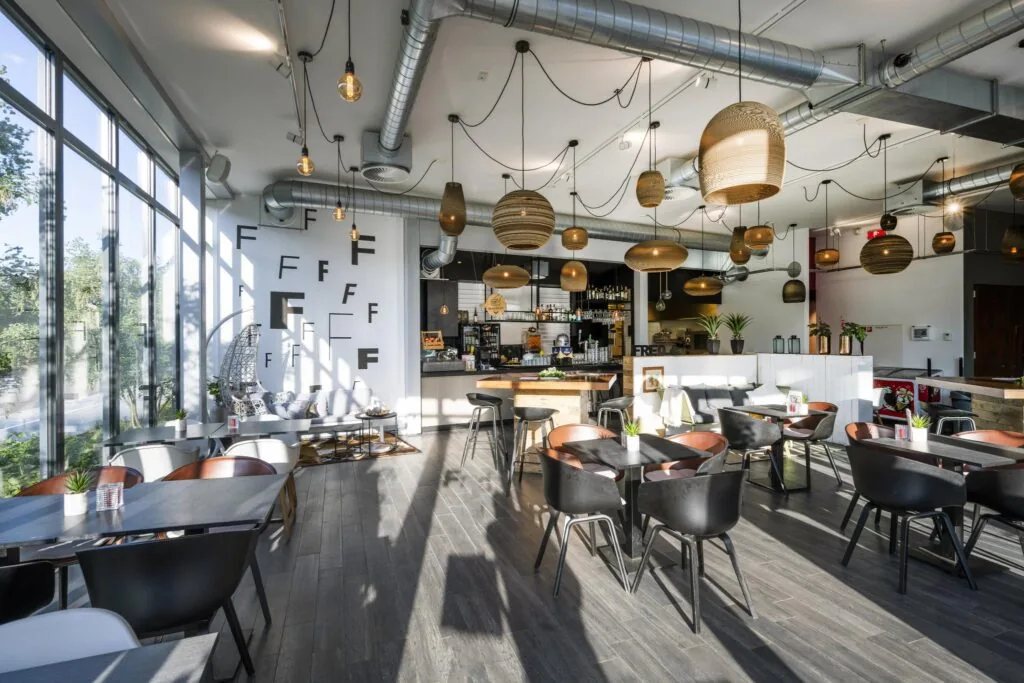 Modern ingericht café-restaurant op de Fred. Roeskestraat met veel natuurlijk licht, houten details en hanglampen.