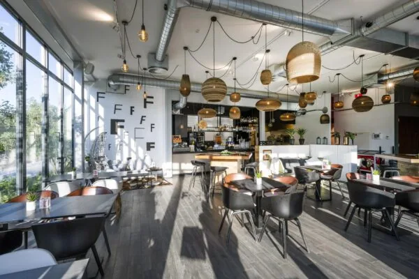 Modern ingericht café-restaurant op de Fred. Roeskestraat met veel natuurlijk licht, houten details en hanglampen.