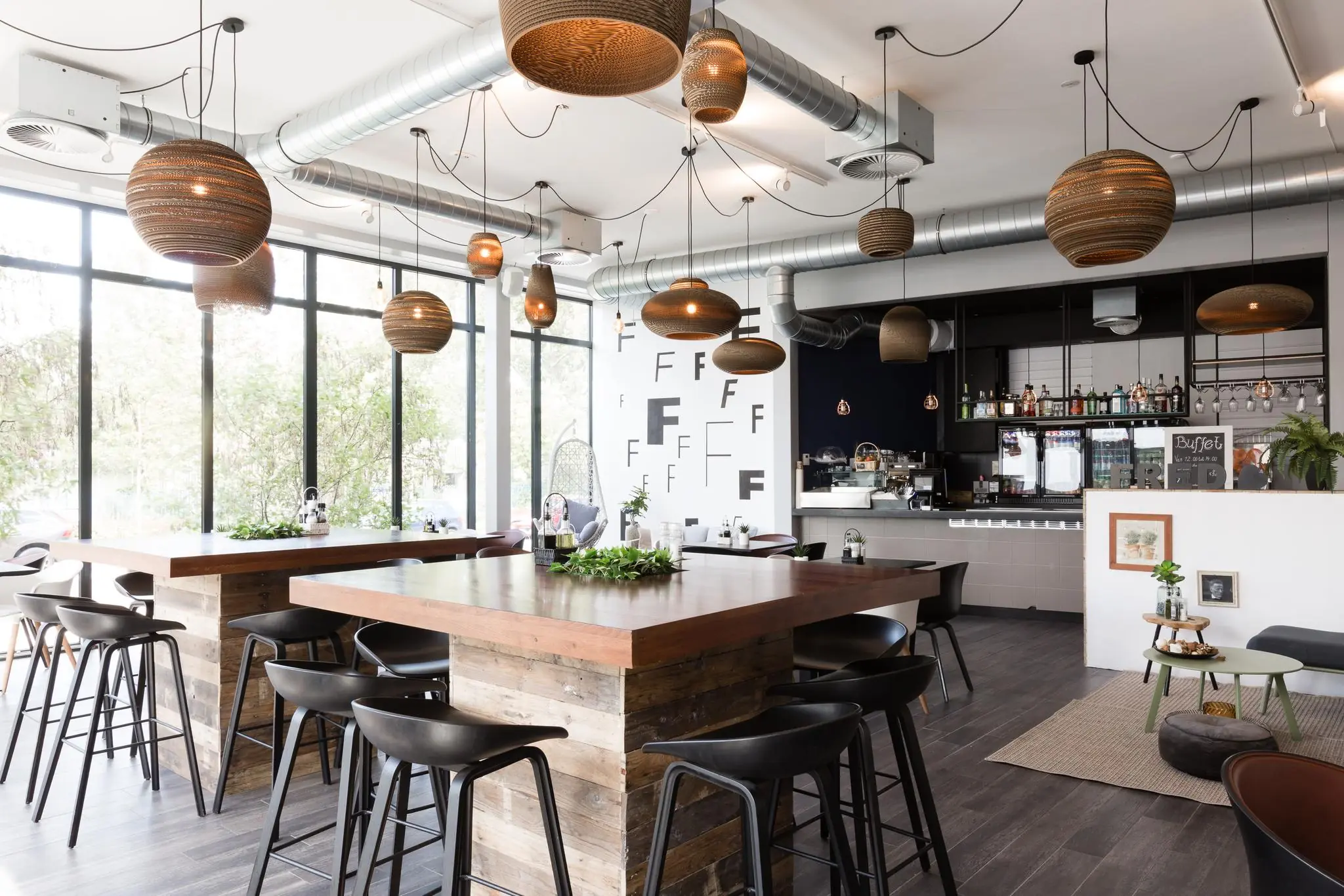 Modern en stijlvol ingericht café aan de Fred. Roeskestraat met houten tafels, industriële verlichting en een gezellige bar.