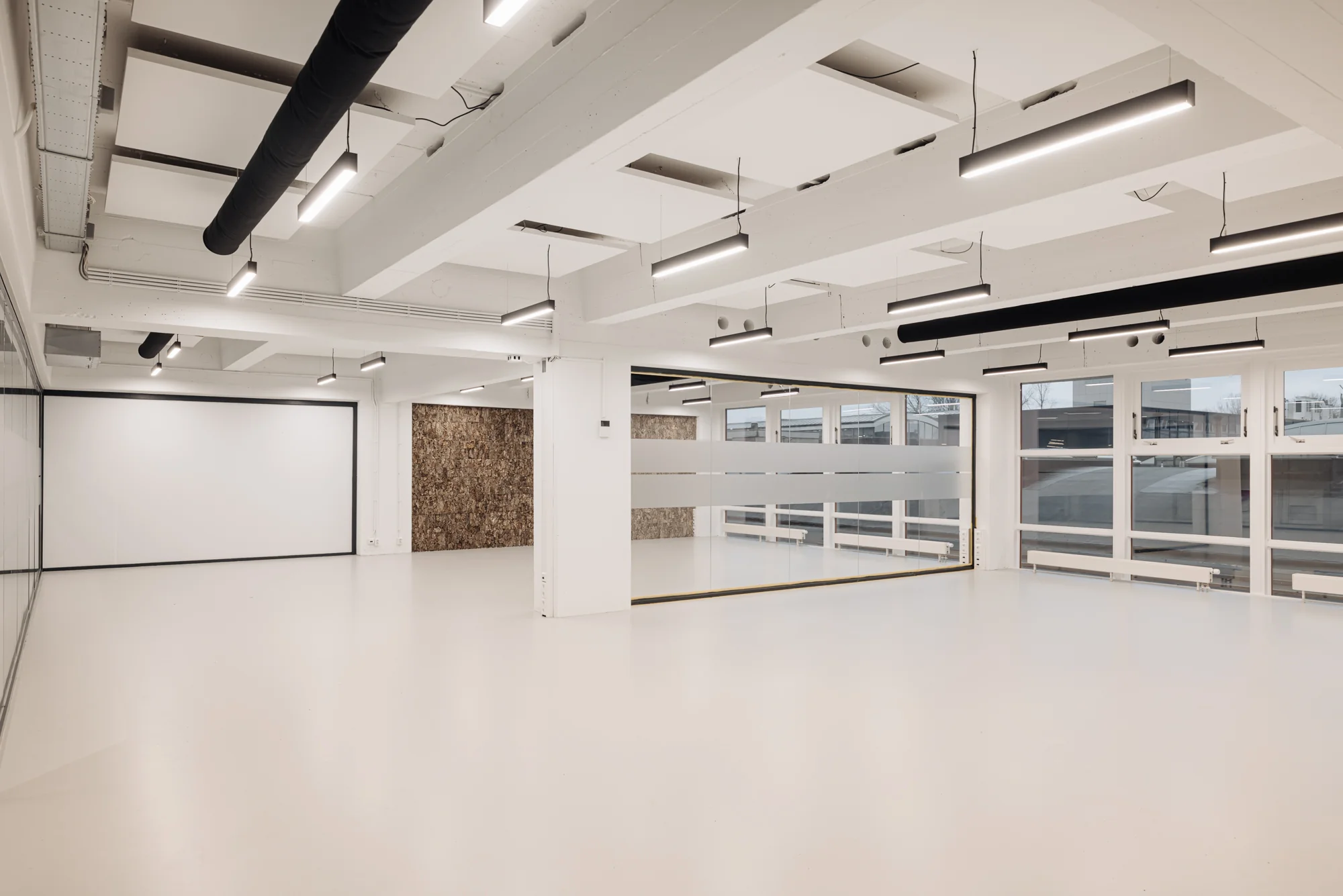 Licht en modern kantoorinterieur aan de Generaal Vetterstraat met grote ramen, witte wanden en industriële plafonddetails.