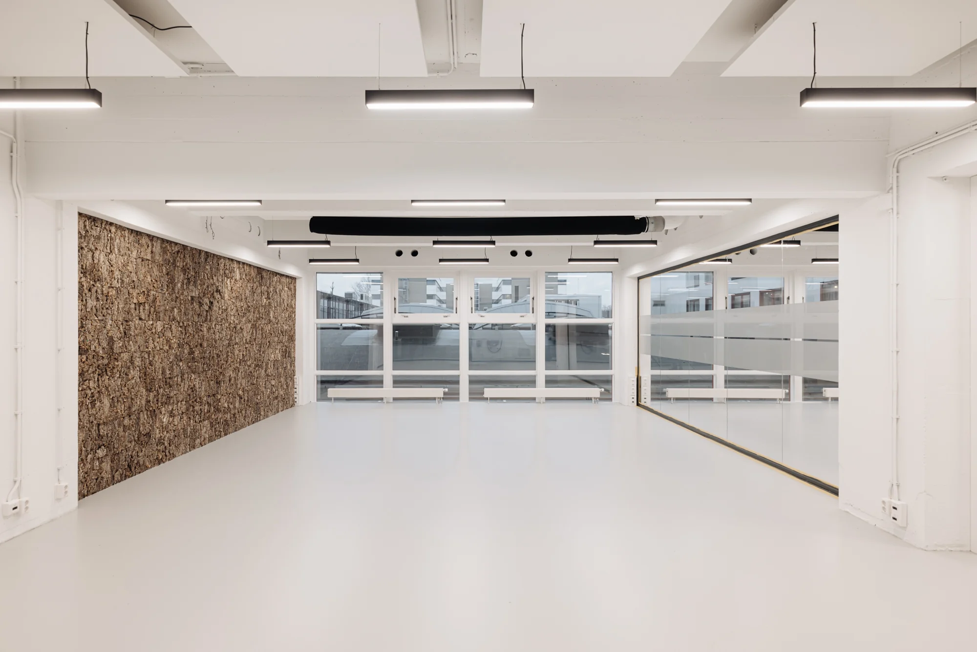 Licht en modern interieur van een lege kantoorruimte aan de Generaal Vetterstraat met kurkwand en glazen wand.