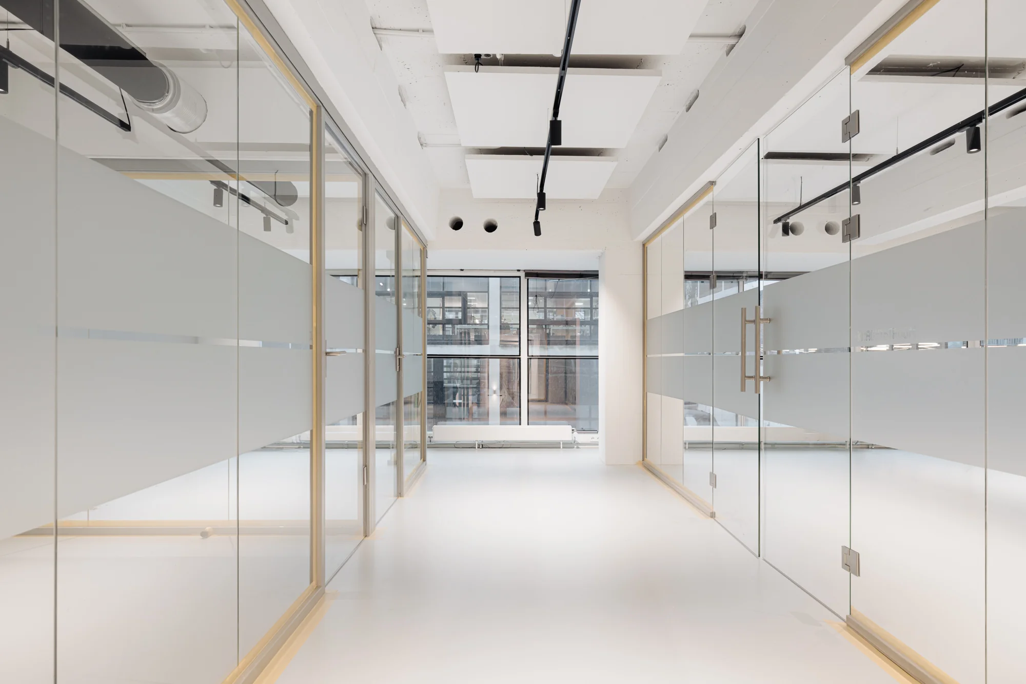 Moderne, lichte kantoorruimte aan de Generaal Vetterstraat met glazen wanden en een minimalistisch interieur.