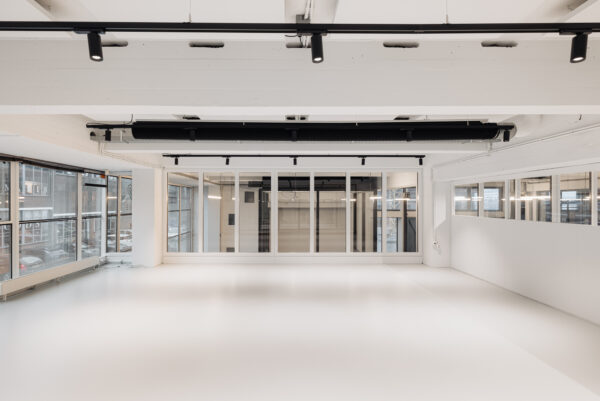 Licht en modern interieur van een leeg kantoor op de Generaal Vetterstraat met grote ramen en glazen wanden.