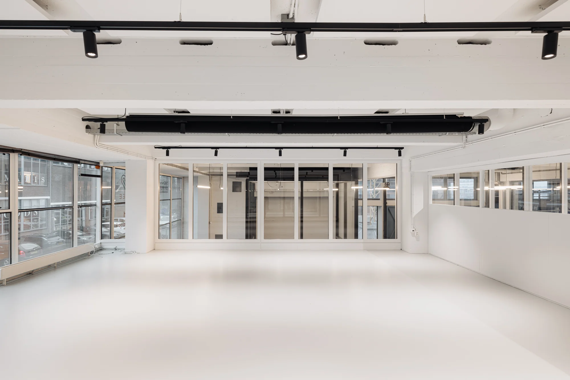 Licht en modern interieur van een leeg kantoor op de Generaal Vetterstraat met grote ramen en glazen wanden.