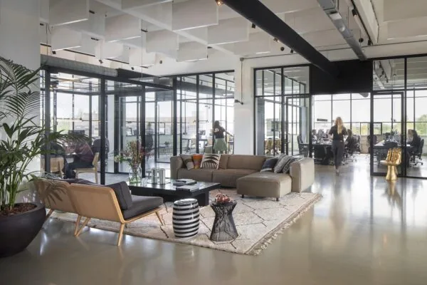 Modern kantoorinterieur aan de Generaal Vetterstraat met glazen vergaderruimtes, een loungehoek en open werkplekken.