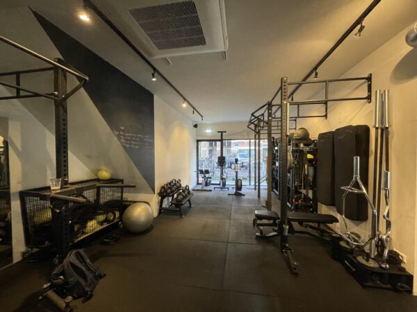 Fitnessruimte aan de Pieter Baststraat met diverse krachttrainingsapparaten, gewichten en een roeimachine.