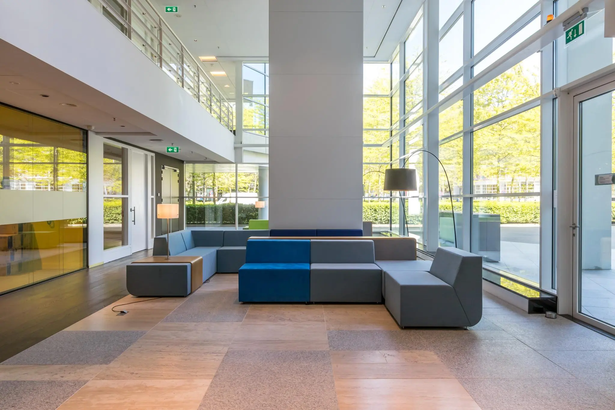 Modern ingerichte wachtruimte met kleurrijke zitbanken en grote glazen ramen aan de Newtonlaan.