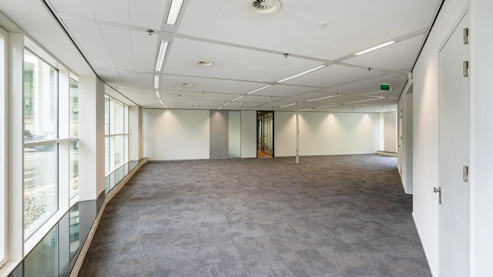 Licht en modern leeg kantoor met grote ramen aan de Newtonlaan.