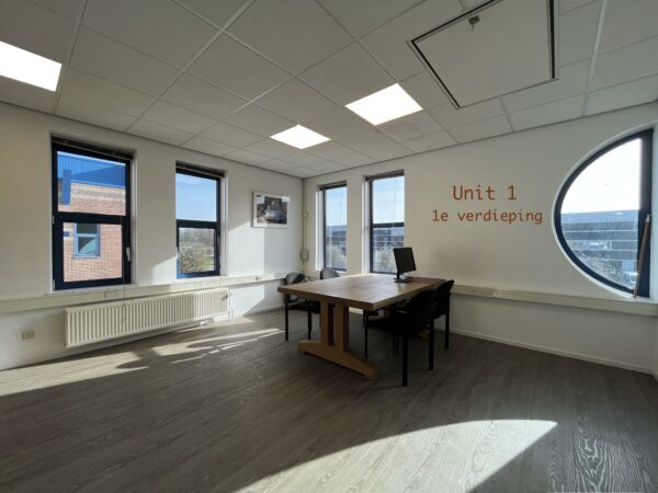 Lichte kantoorruimte op de eerste verdieping van Unit 1 in het gebouw Bergveste, met een tafel, stoelen en een computer.