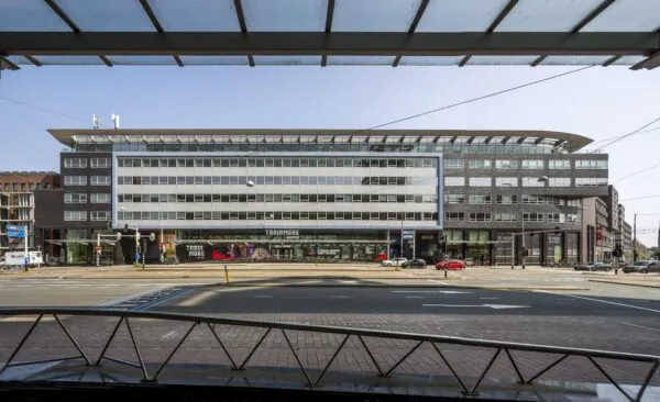 Modern kantoorgebouw aan het Bos en Lommerplein in Amsterdam met zicht op winkelruimtes en het verkeer op straat.