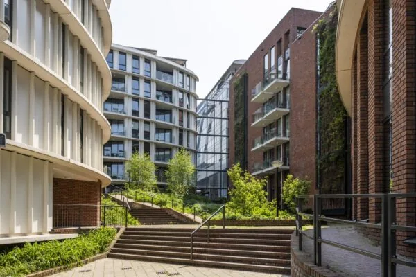 Moderne appartementencomplexen met veel glas en baksteen rond een groen plein op het Bos en Lommerplein in Amsterdam.